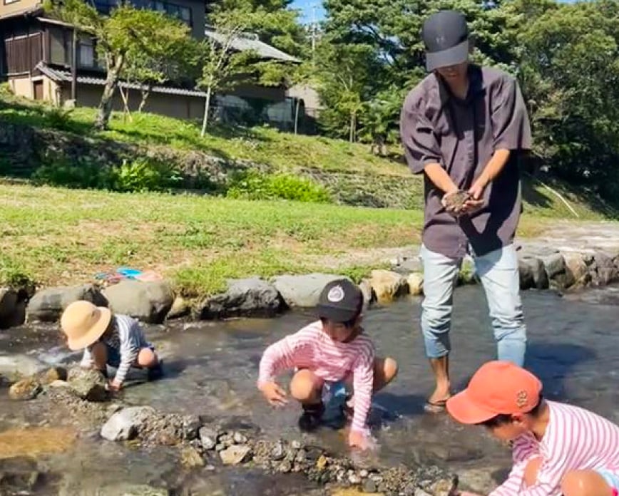 子供3人と水辺で遊んでいる