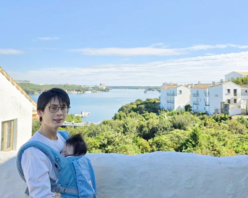 子供を前で抱えて笑顔を向けている